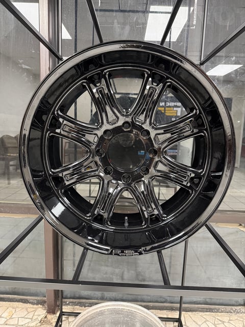 Black chrome custom car wheel with multi-spoke design displayed in showroom window